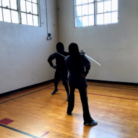 Marsha and John at the Intro/Refresher to Italian Sabre at Indes Ferox Gladio, March 2019--here Marsha is about half-way through the arc of a descending molinello to the head.